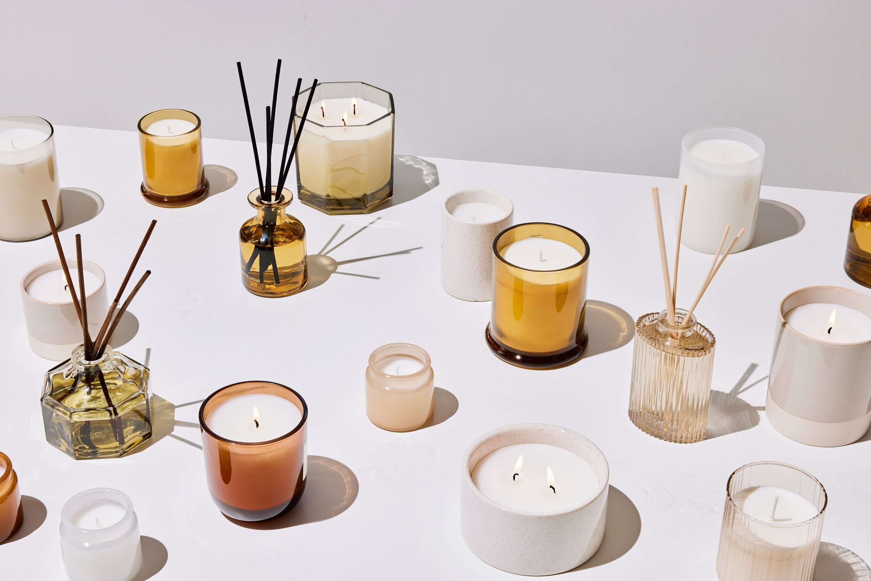Transform Your Space with Crystal Infused Reed Diffusers on a table with various candles and diffusers.