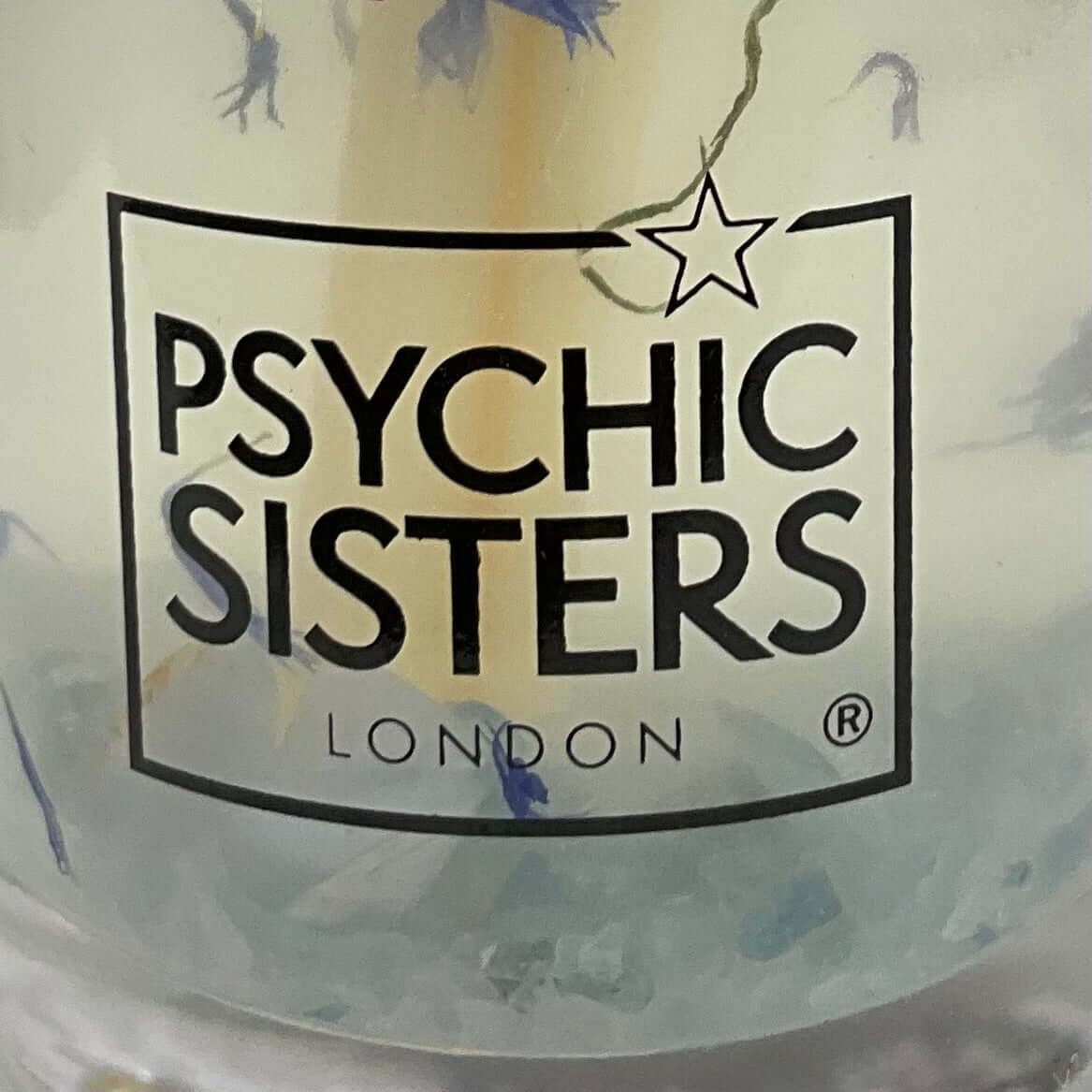 Logo of Psychic Sisters London on a product packaging with a star symbol.
