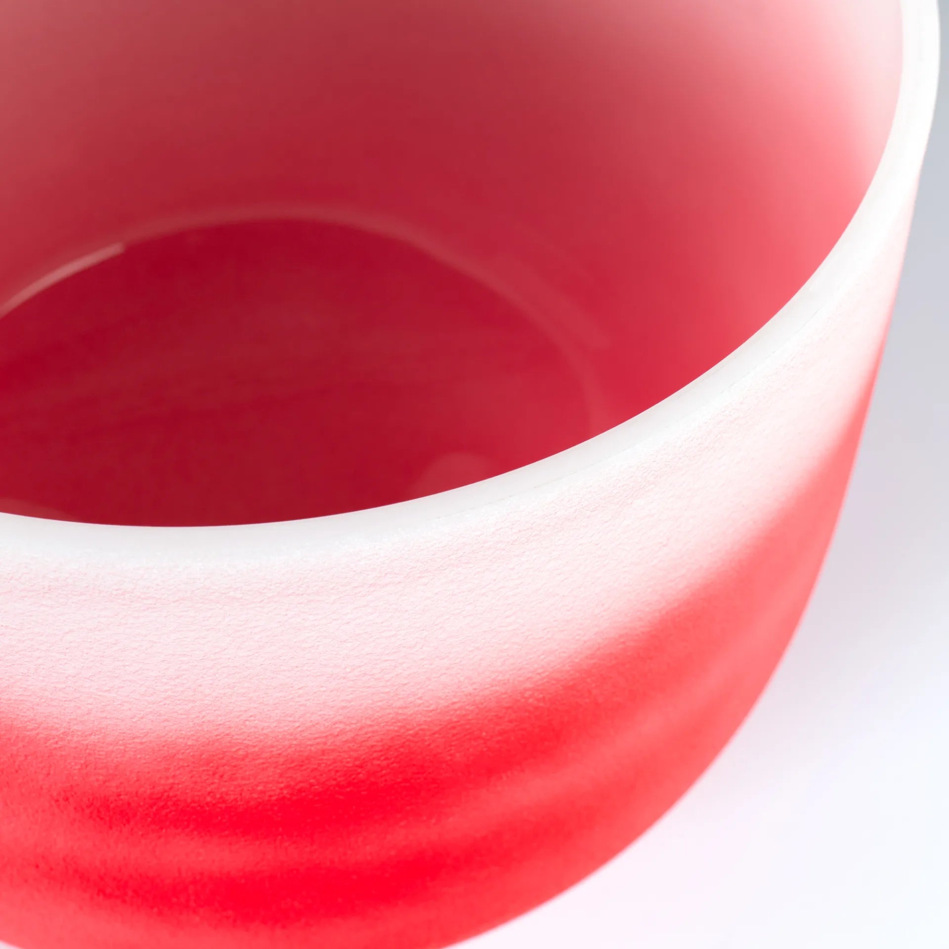 Close-up of a red 12 inch crystal singing bowl C note, showcasing its smooth surface and vibrant color.