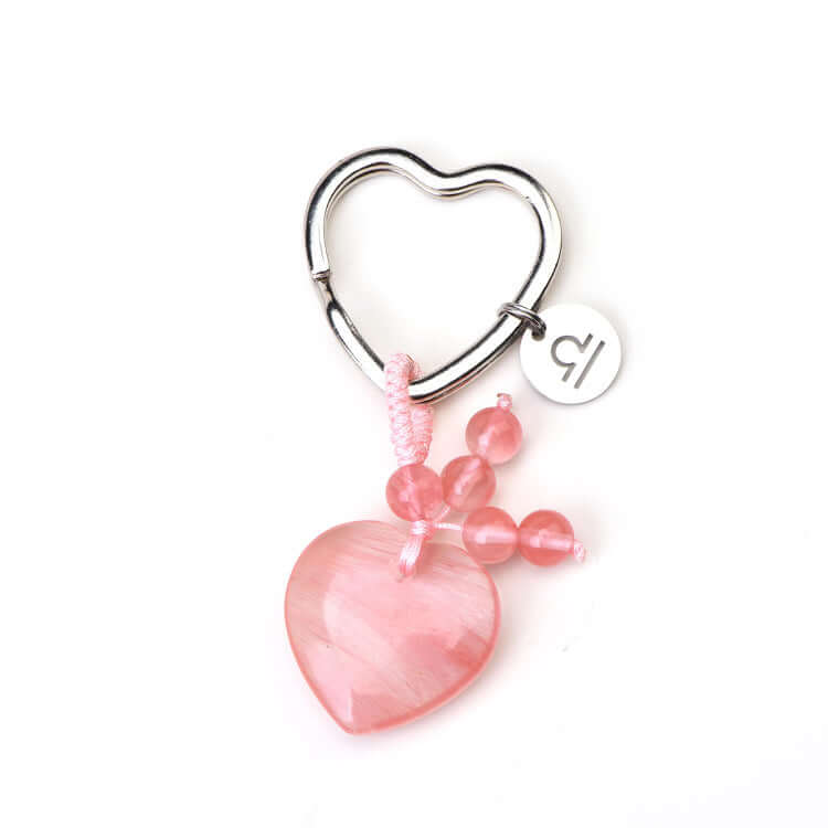 Heart-shaped keychain with pink heart charm and beads on a white background