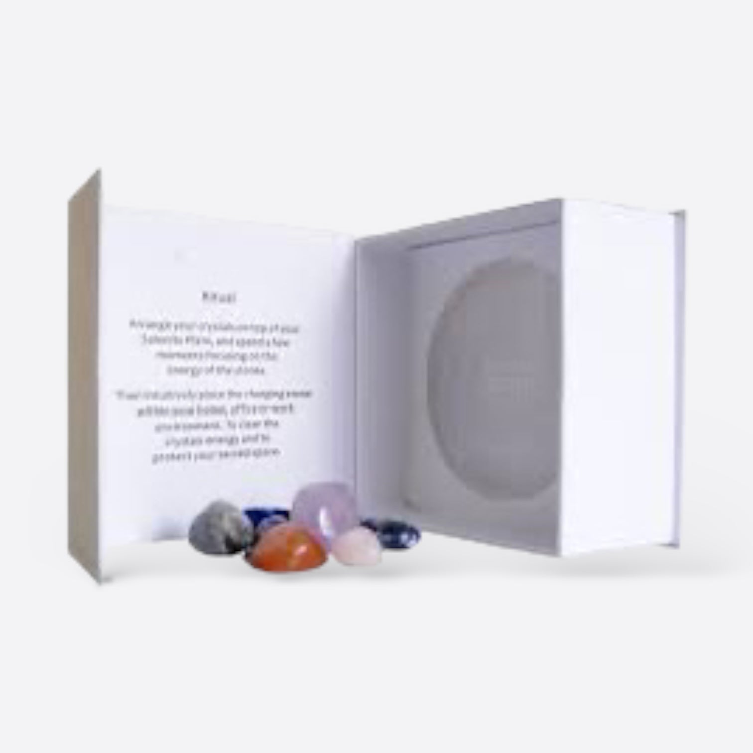 Selenite Charging Plate inside a box with various crystals, promoting cleansing and energizing properties.