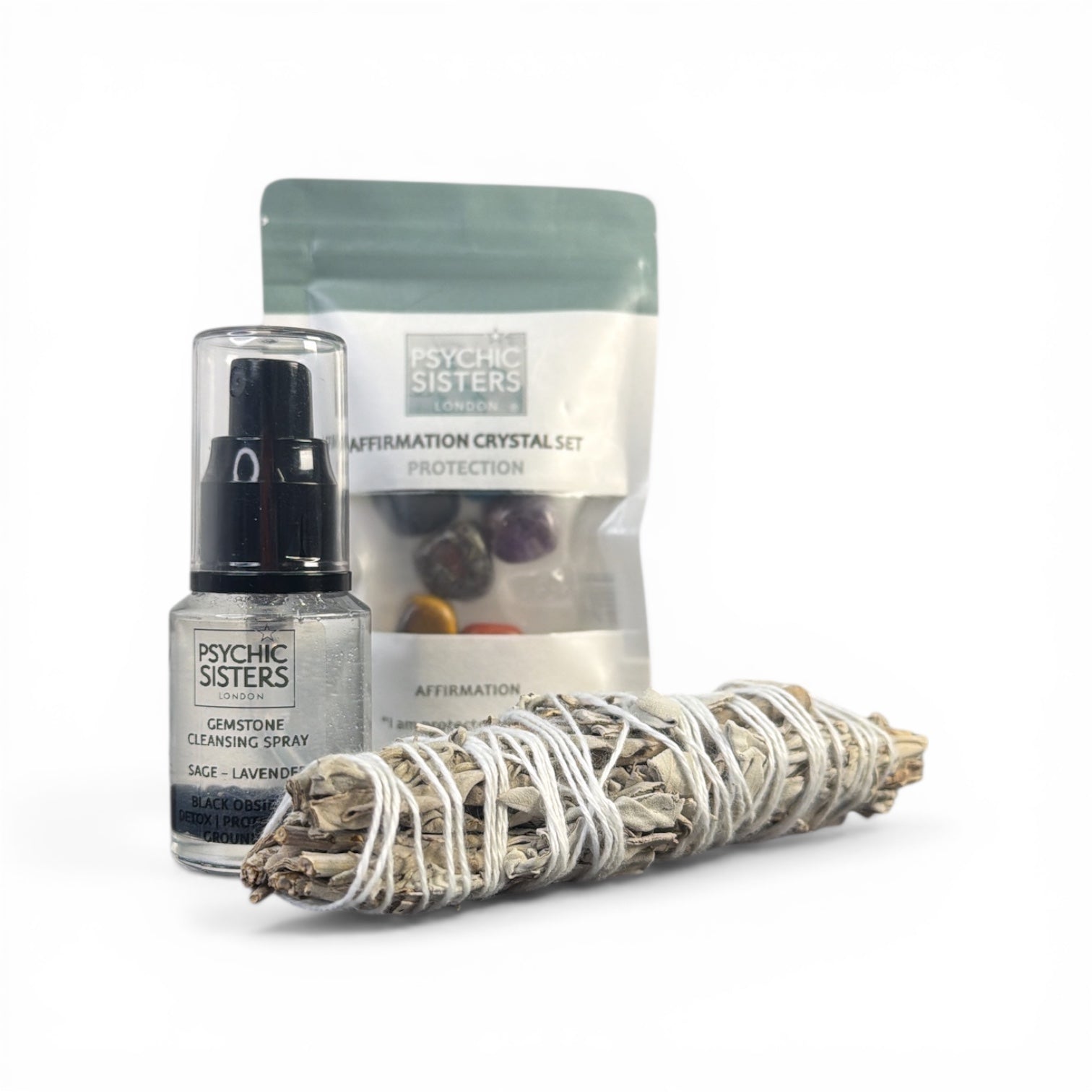 Psychic Sisters cleansing spray, crystal set, and sage on a white background