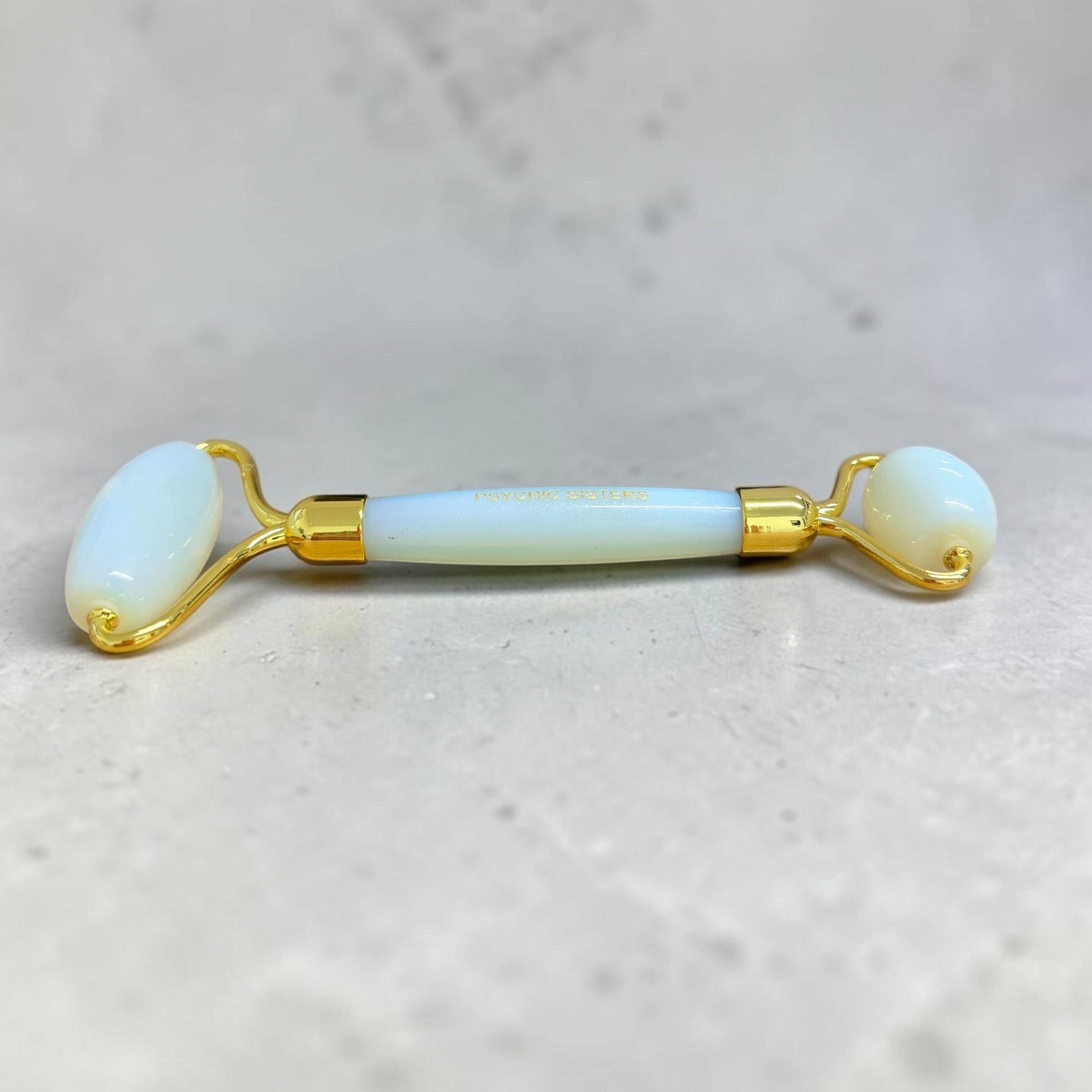 Beauty roller with gold accents on a light gray background