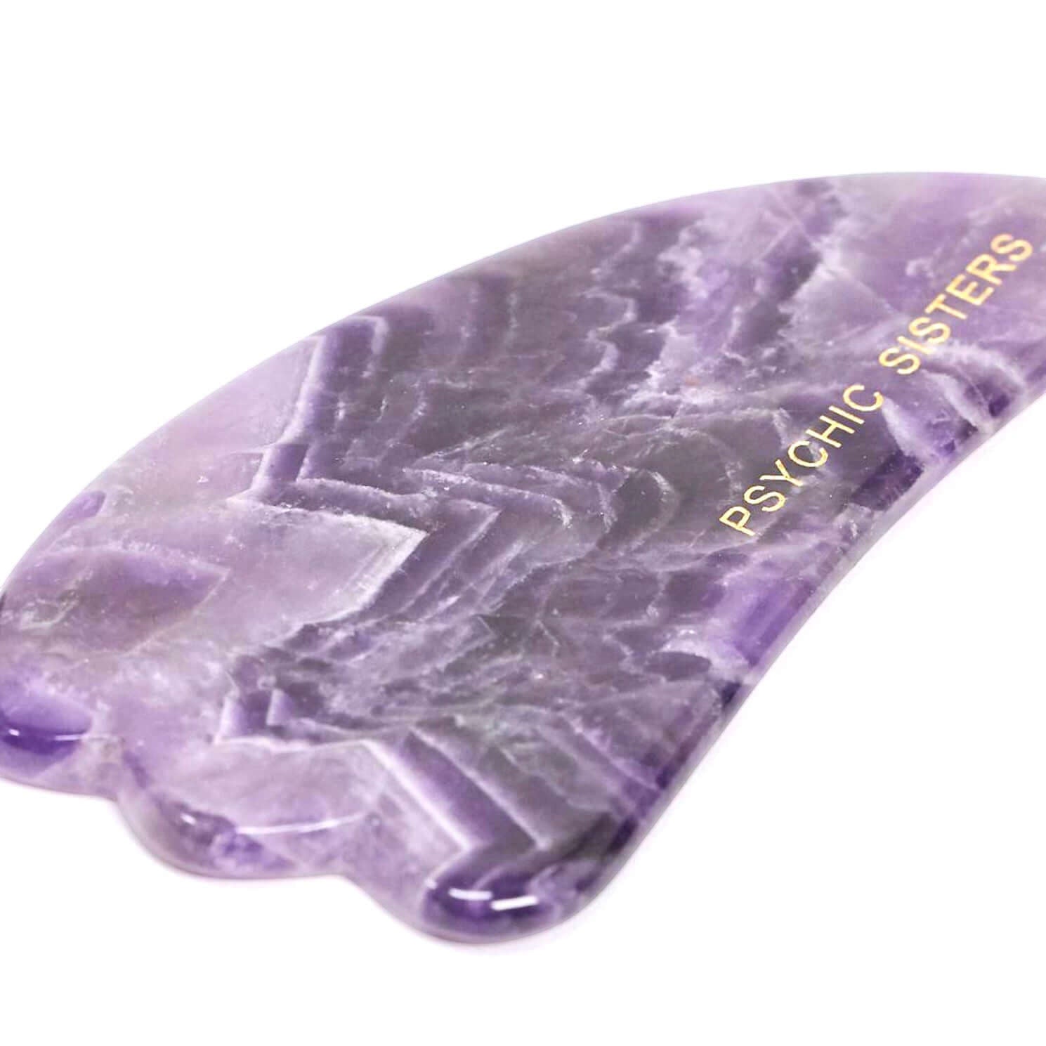 Psychic Sisters purple amethyst gua sha facial massage tool with natural stone banding and gold logo detail