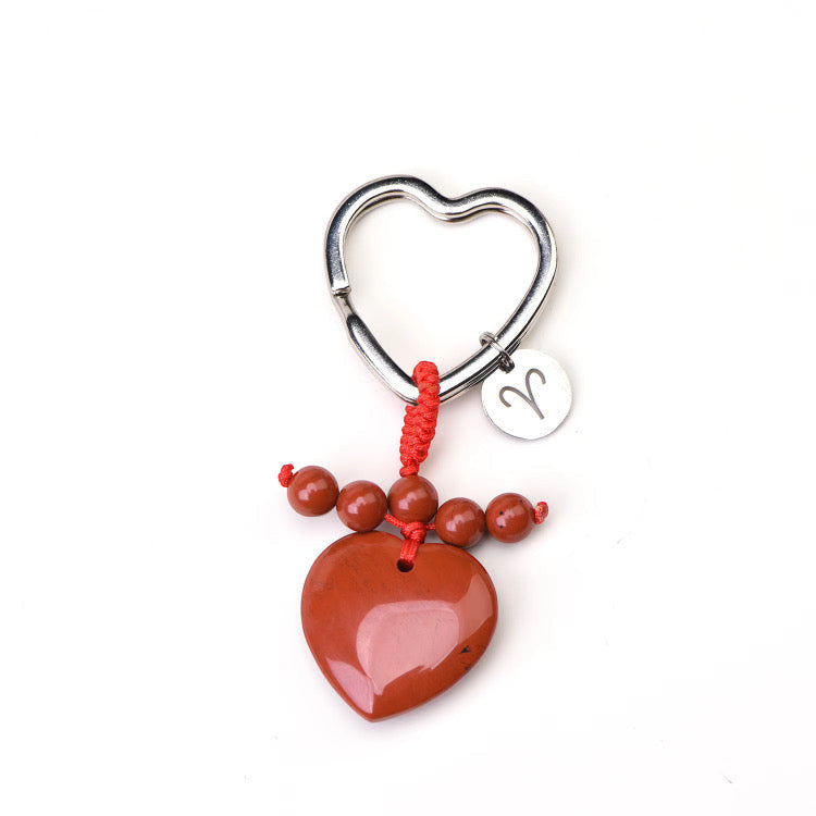 Psychic Sisters Aries zodiac keyring with a heart-shaped strawberry quartz, silver symbol disk, and red cord beads.