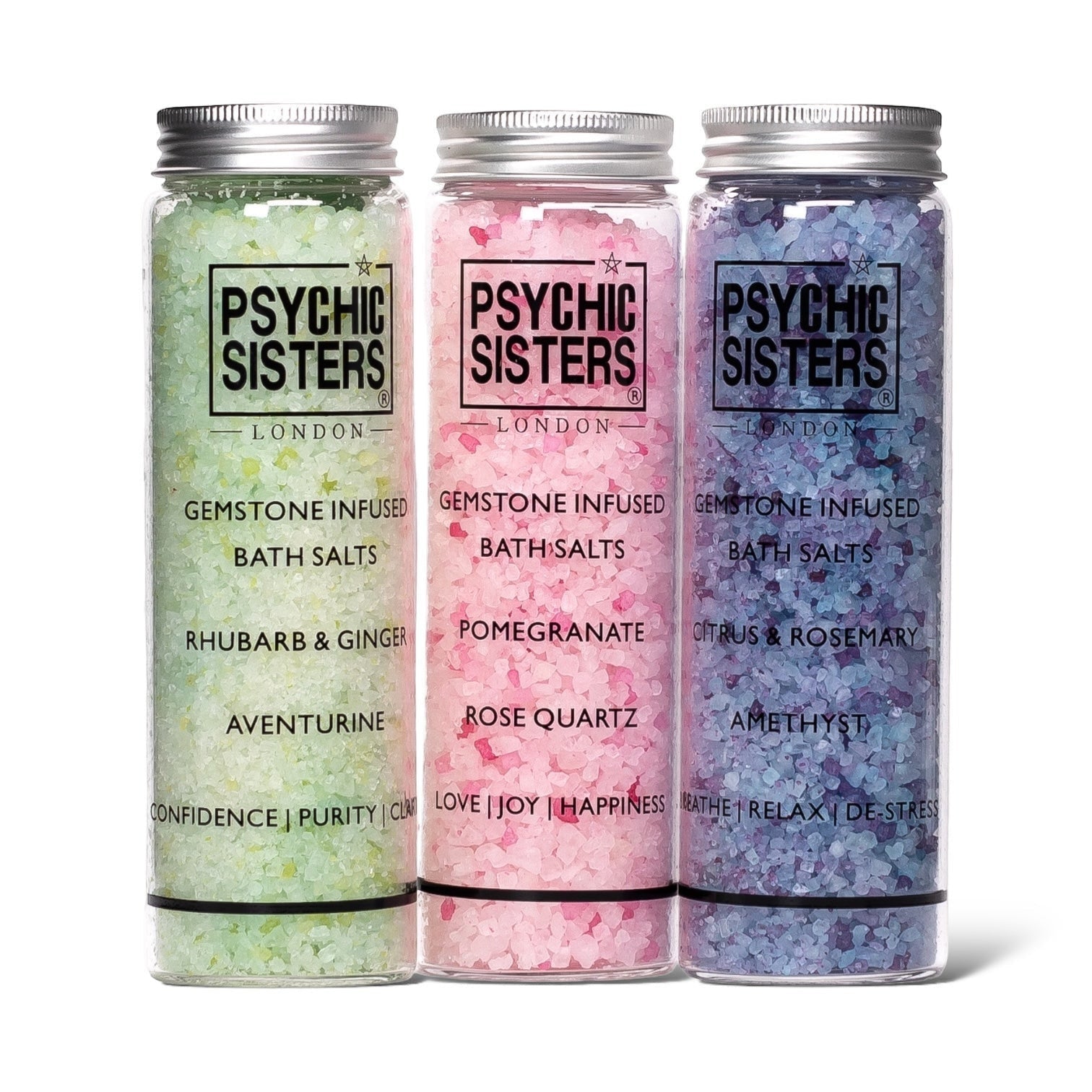 Psychic Sisters gemstone infused bath salt shots in glass bottles with green, pink, and purple crystals.