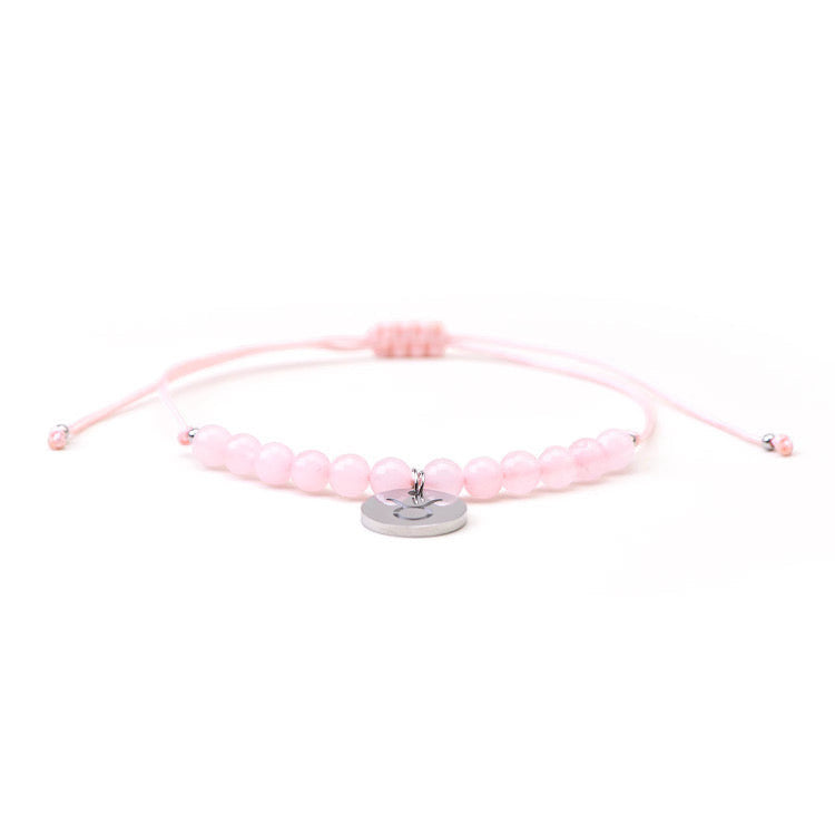 Psychic Sisters zodiac crystal bracelet with light pink beads and a silver star sign charm on a cord