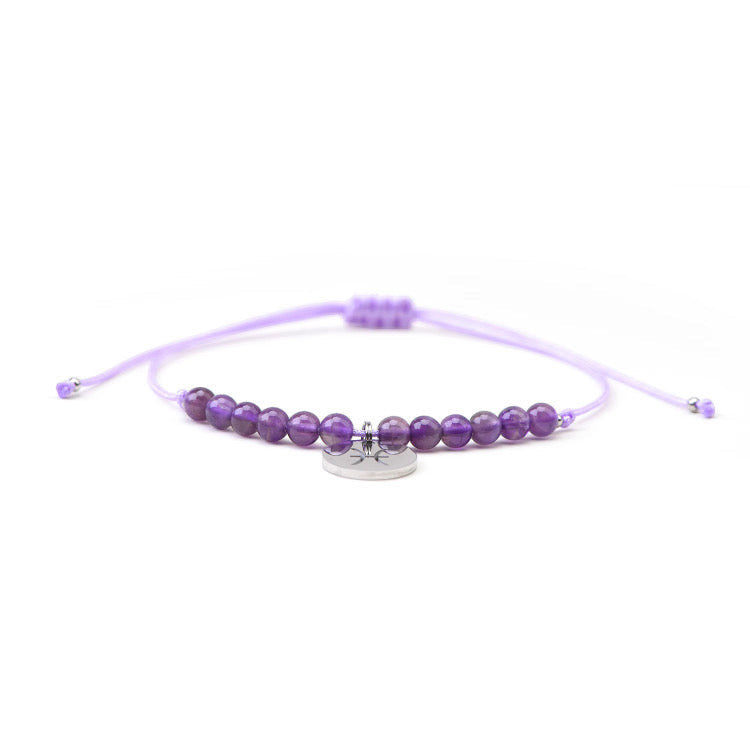 Psychic Sisters Pisces zodiac crystal bracelet with purple amethyst beads and a silver star sign charm on a cord.